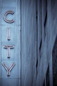 City neon sign with building in blue tones