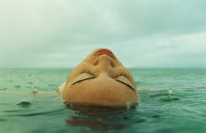 Woman lying  on back face up in water