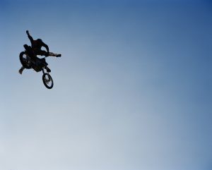 Man performing stunts on motorcycle, low angle view